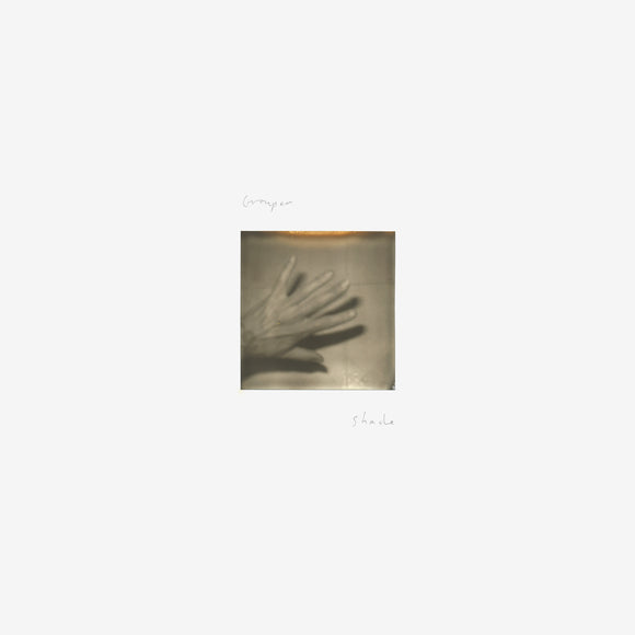 LP edition of Shade by Grouper on Kranky Records (the album artwork is a small square black and white photograph of a hand in the centre of a plain white background; the artist name and album title are hand-written above and below the photograph in light cursive text)