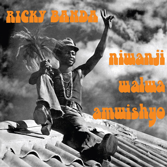 Niwanji Walwa Amwishyo by Ricky Banda on Now-Again Reacords (the album sleeve is a black and white photograph of Ricky Banda sat on a rooftop against a dramatically cloudy sky; Banda wears flared jeans, platform shoes, a vest, necklaces and hat, and their left hand is raised in a peace sign; the artist's name is printed in an orange uppercase seventies font; the album title is printed in lowercase in the same orange font))