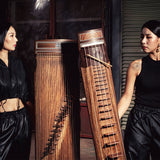 Ha Suyean and Hwang Hyeyoung of the duo Dal:um holding their geomungo and gayageum, and looking at each other
