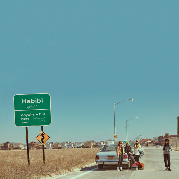 Anywhere But Here by Habibi on Kill Rock Stars (the album artwork is a colour photograph of the four-piece band stood beside a car on a road beneath a clear blue sky. The band name and album title are written on a green road sign to the left of the car, on a grass verge, in white text, in both English and Arabic).