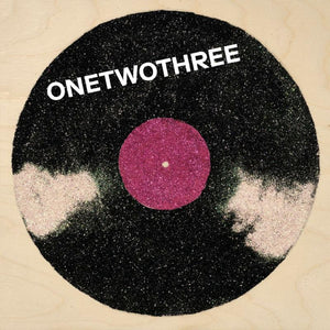 ONETWOTHREE's self-titled debut album on Kill Rock Stars (the album artwork is an illustration of a record with a purple labek in a wooden background)